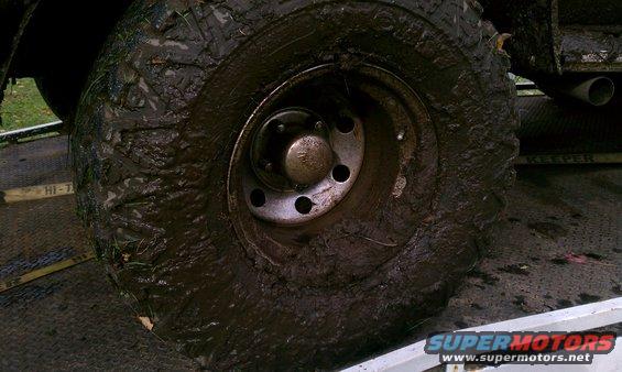 Mud-covered tire and exhaust pipe on a vehicle