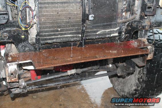 front end of a vehicle with radiator and custom rusty metal bracket installed