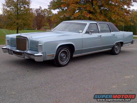 Light blue Lincoln Continental sedan with a black vinyl roof, parked on asphalt