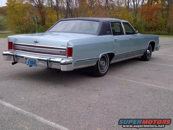 Light blue Lincoln Continental with a black vinyl roof parked on asphalt