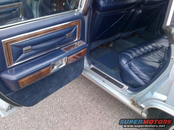 Blue leather interior with wood trim on door panel and rear seats