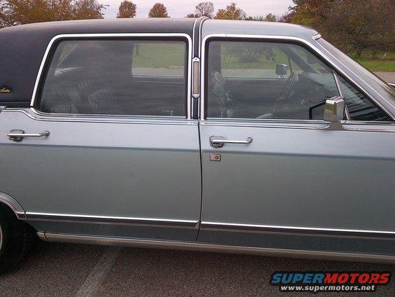 Light blue sedan with a black vinyl roof, chrome trim, and tinted windows