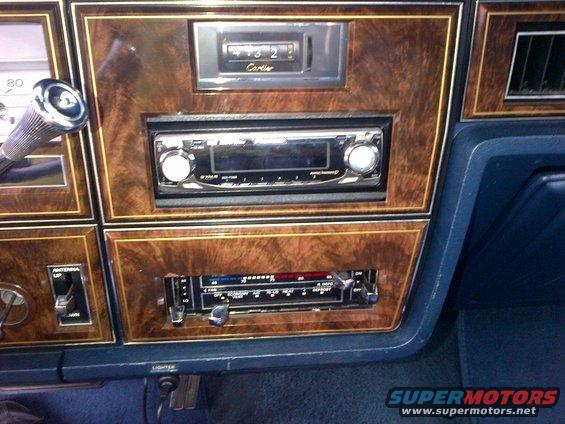 Interior dashboard with wood grain trim, aftermarket stereo, and climate controls