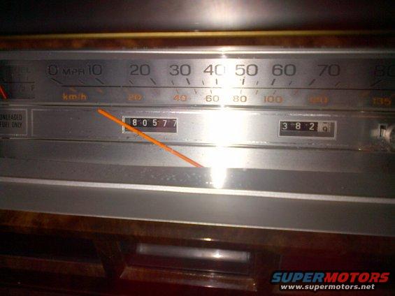 Car dashboard showing speedometer with needle pointing past 60 mph, odometer reads 80577, and trip odometer reads 382.6
