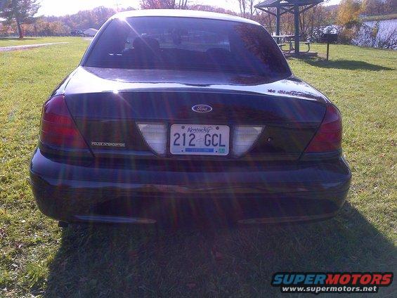 Black Ford Crown Victoria Police Interceptor rear view, license plate 212 GCL, parked on grass