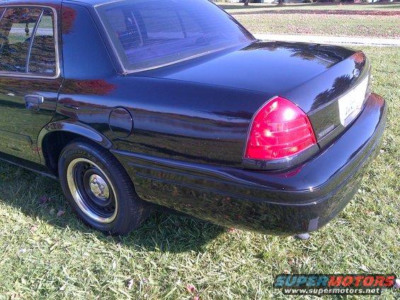 Rear quarter view of a black 2001 Ford Crown Victoria parked on grass