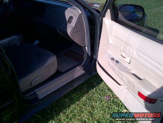 Interior of a 2001 Ford Crown Victoria showing the driver's side door panel and dashboard