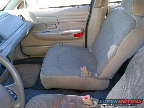 Tan interior of a 2001 Ford Crown Victoria showing the driver's seat, dashboard, and door panel