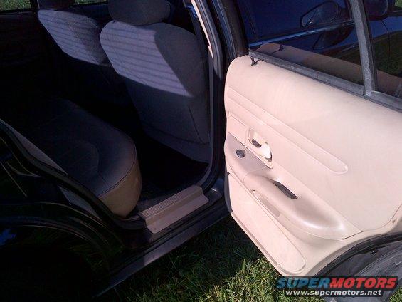 Interior view of car door panel and rear seats