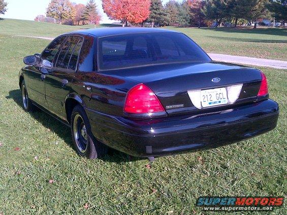 Black 2001 Ford Crown Victoria with a license plate reading 212 GCL parked on grass