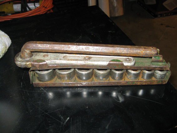 Rusty socket wrench set with metal sockets in a green metal holder. Text reads "MADE IN U.S.A."