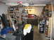 2004 Aston Martin Virage - This image depicts a disorganized garage space filled with various items, including shelves, a workbench, and storage containers.