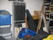 2004 Aston Martin Virage - A disorganized garage scene with various stored items, including plastic bins and rolled-up materials.