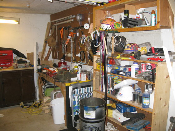 Garage interior with workbench, tools, shelves, and storage bins