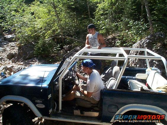 1977 Ford Bronco with white roll cage on rocky trail