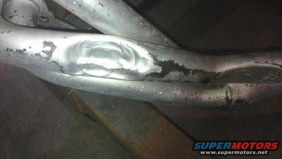 Close-up of welded exhaust pipes with some corrosion and peeling paint