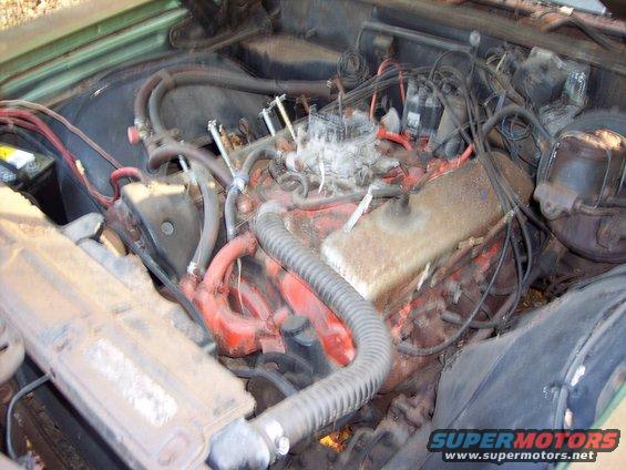 Engine bay with V8 engine, carburetor, and radiator hoses visible