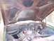 1970 Chevrolet Chevelle - The underside of a car's hood shows significant rust, with a blurry view of the engine bay below.