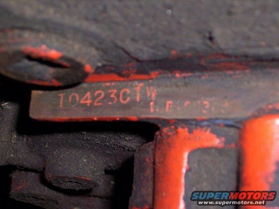 Close-up of red engine block with stamped numbers T0423CTW and 1.F.R.3