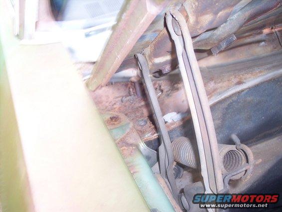 Rusty hood latch mechanism and spring assembly inside a car