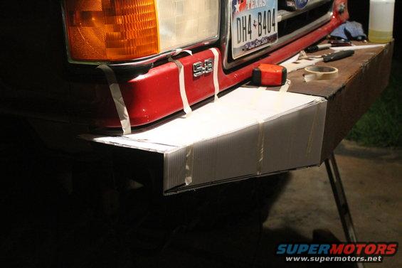 1990 Ford Bronco front bumper with tape holding cardboard mockup