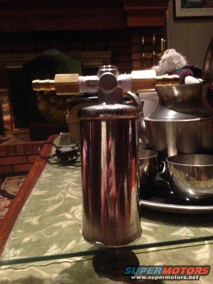 Chrome fuel filter with brass fittings on a table