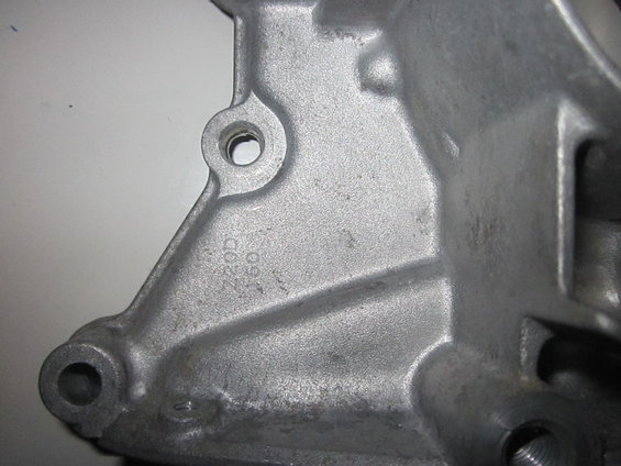 Close-up of a metal casting with stamped numbers '220D' and '160'