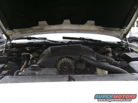 Engine bay of a 1998 Ford Crown Victoria. Shows the alternator, air intake, and coolant reservoir