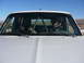 1988 Ford Bronco - Two people inside a 1988 Ford Bronco with a roll cage, desert landscape visible through windows.
