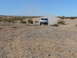 1988 Ford Bronco - A white off-road SUV drives through a dusty desert landscape.