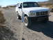 1988 Ford Bronco - A white 1992 Ford Bronco navigates a dusty desert road, passing a course marker.