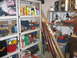 2004 Aston Martin Virage - A cluttered shelving unit contains a variety of items including cleaning products, tools, and storage containers, suggesting a workshop or…