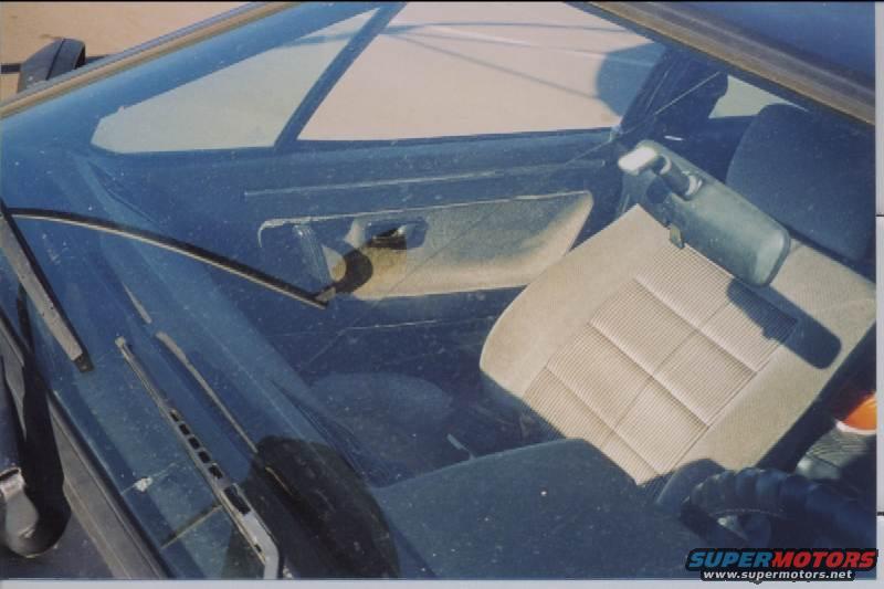 Interior view of a 1985 Volkswagen Scirocco showing the passenger seat, door panel, and dashboard