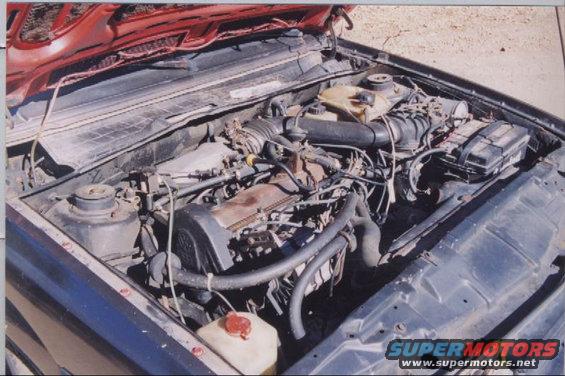 1985 Volkswagen Scirocco engine bay with hood open. Shows engine, hoses, and air intake