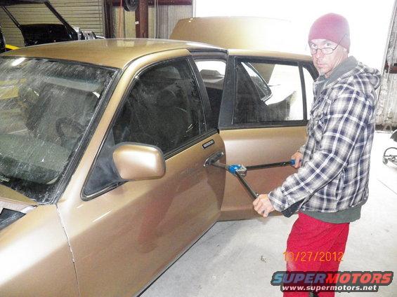 101_0573.jpg Mike waiting for me to hold the rivet gun while installing the door handles.  NOTE: If using a manual rivet tool and you are close to a freshly painted car body, always have someone hold the tool for when the rivet 'breaks' off during install.