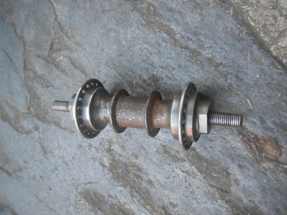 Rusty bicycle hub with two flanges and threaded axles
