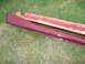 1993 Mazda MX-3 - Two car side skirts, one maroon and one primed yellow, are shown on a grassy surface.