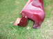 1993 Mazda MX-3 - A red car part, possibly a side skirt, lies on the grass with visible mounting points.