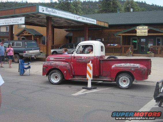 Red and white Ford F-series pickup truck from the late 1940s parked on a street