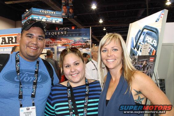 Three smiling people at a trade show with Ford and Polaris branding visible