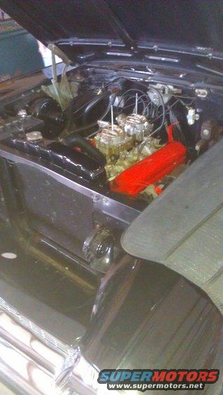 Engine bay with dual carburetors and red valve covers