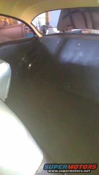Interior shot of a car, showing the dashboard and part of the passenger seat. A watermark says SUPERMOTORS.NET
