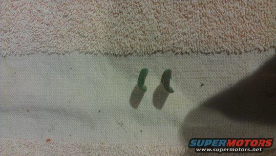 Two green plastic clips on a white cloth