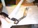 1991 Ford Crown Victoria - Brake pedal assembly with metal linkage being held by a hand.