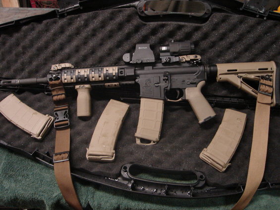 AR-15 style rifle with tan furniture, multiple magazines, and optics in a case
