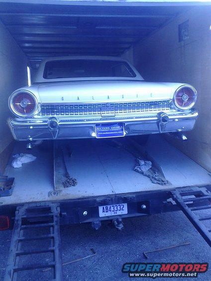 White 1960 Ford Galaxie rear view, parked on a trailer inside a garage
