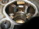 2004 Aston Martin Virage - A close-up view of a metal pipe threading die, showing its intricate teeth and oily surface.