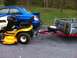 2007 Subaru Impreza - A blue Subaru sedan is hitched to a trailer carrying a yellow Cub Cadet riding mower.