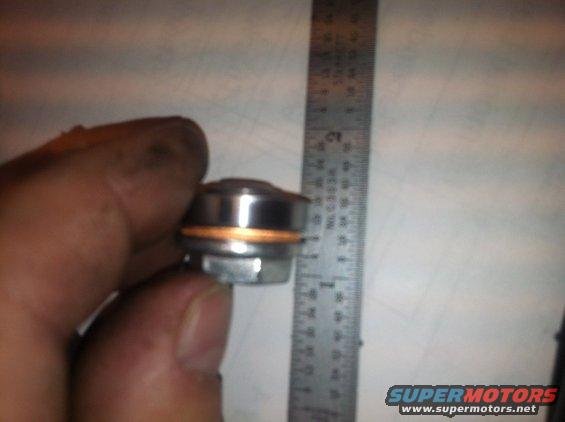 Drain plug with copper washer next to ruler