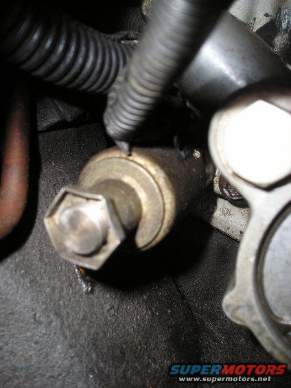 Close-up of an oil pressure sensor with a hex head and electrical connector